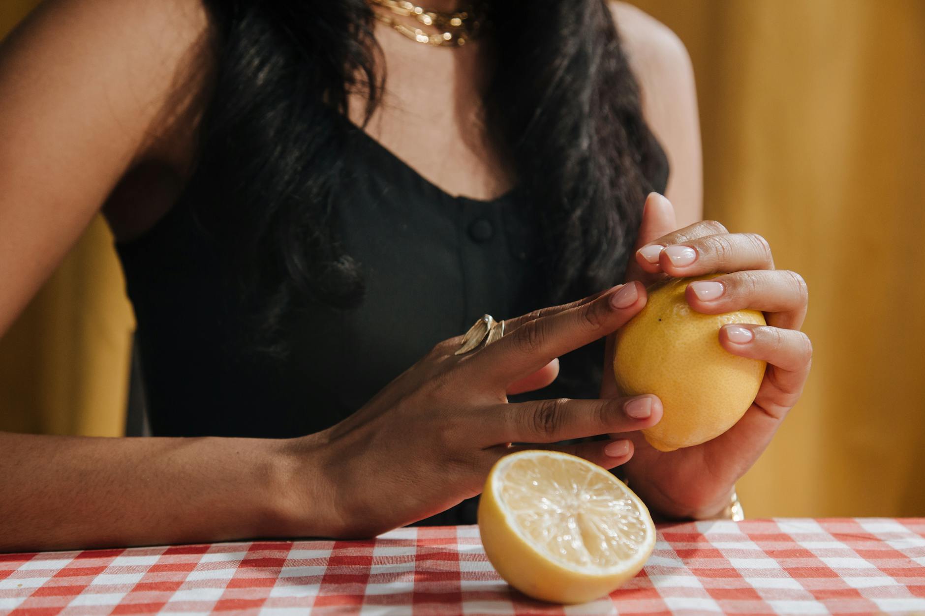 Close-up of hands holding a sleek blue vibrator against a purple background during intimate moment