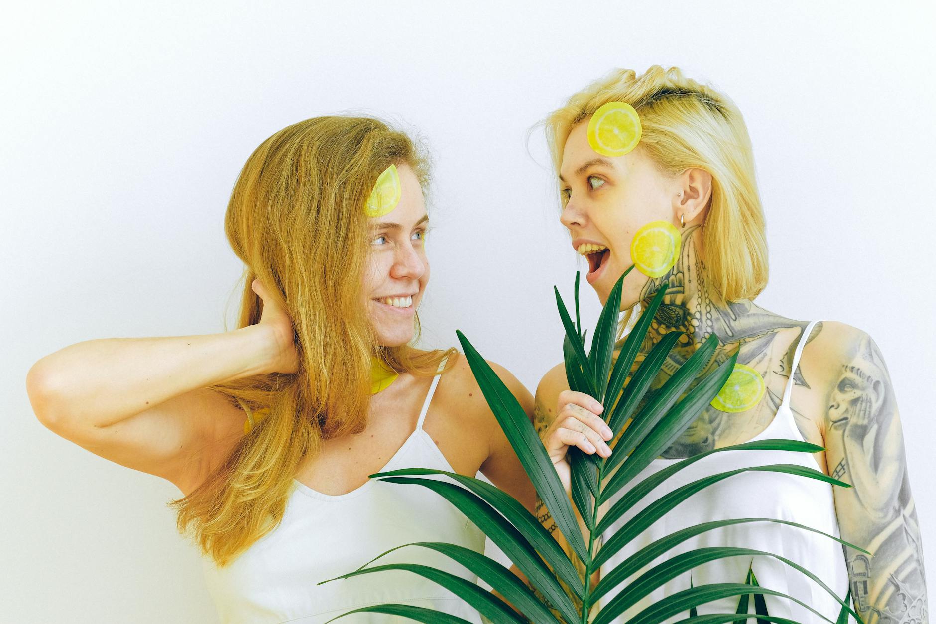 Two women smiling together while enjoying fresh citrus fruit, representing joy, openness, and connection.