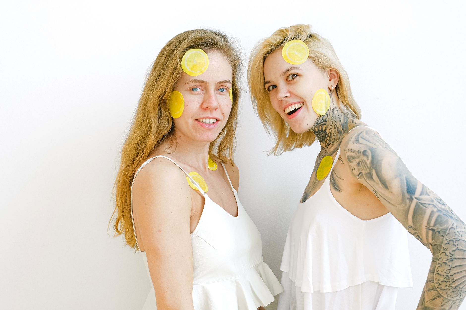 Hand holding a fresh lemon against a bright yellow background