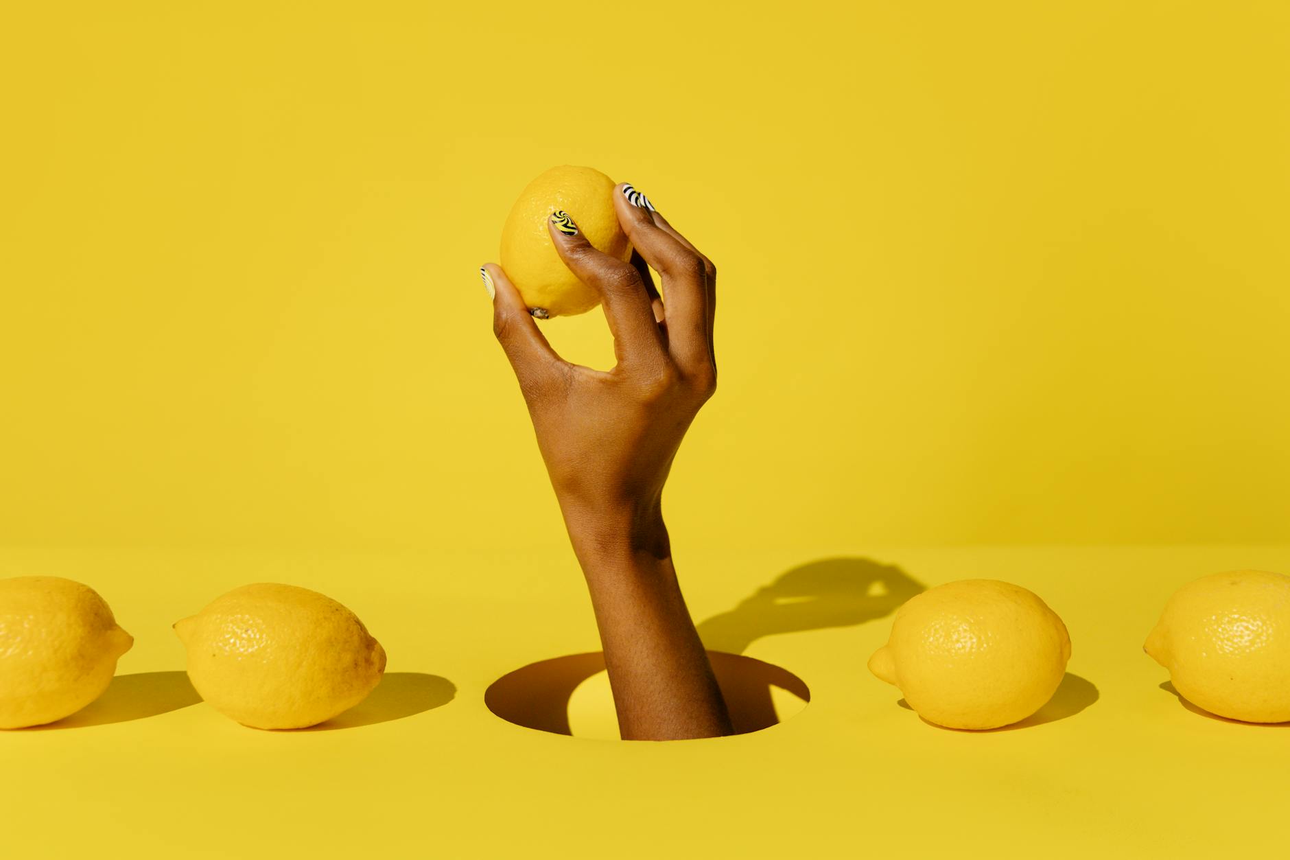 Hand holding a sleek orange vibrator against a minimalist purple backdrop
