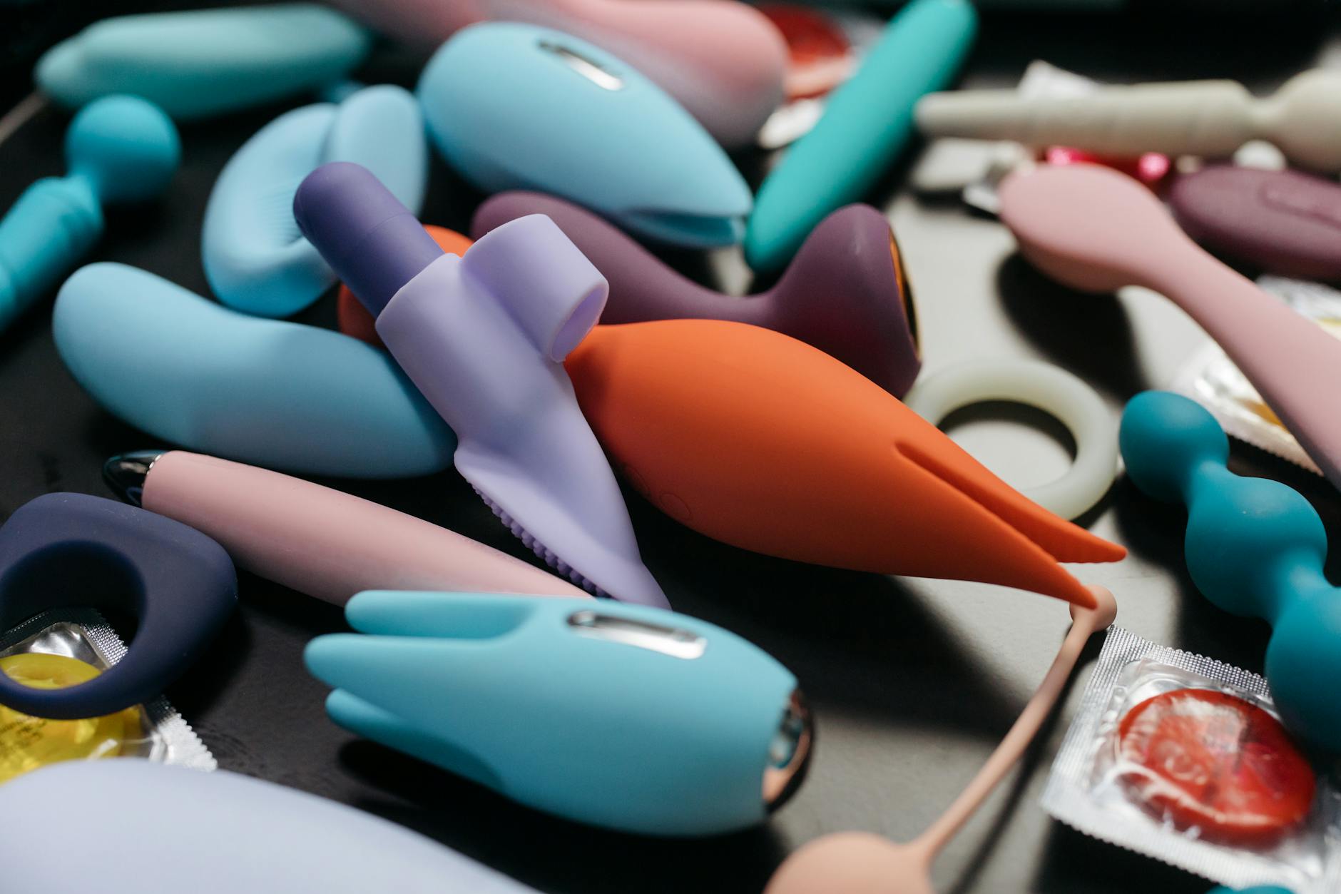 Hands holding a sleek vibrator against a purple background, intimate and close.