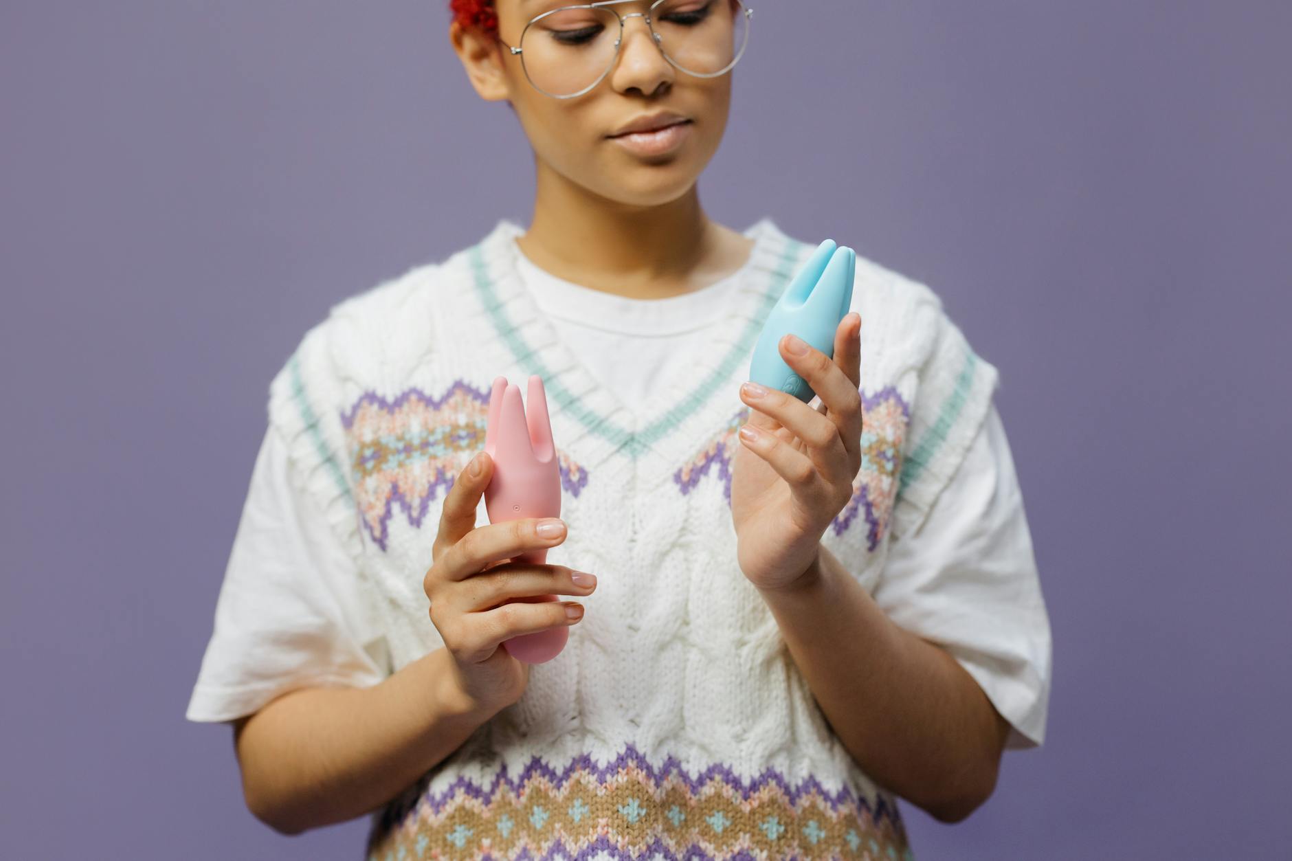 A young couple standing together indoors, holding a blue vibrator, symbolizing modern intimacy and trust.