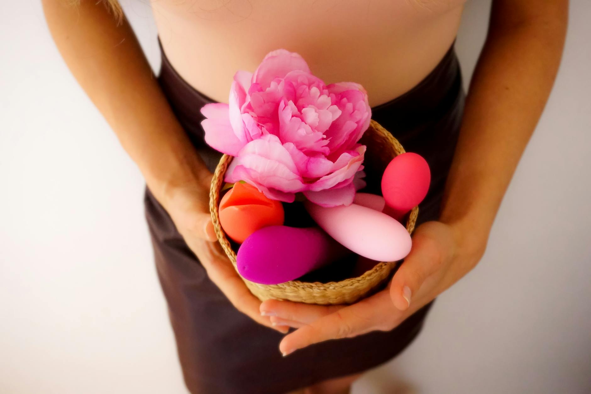 Woman holding colorful vibrators, representing measured approach to pleasure
