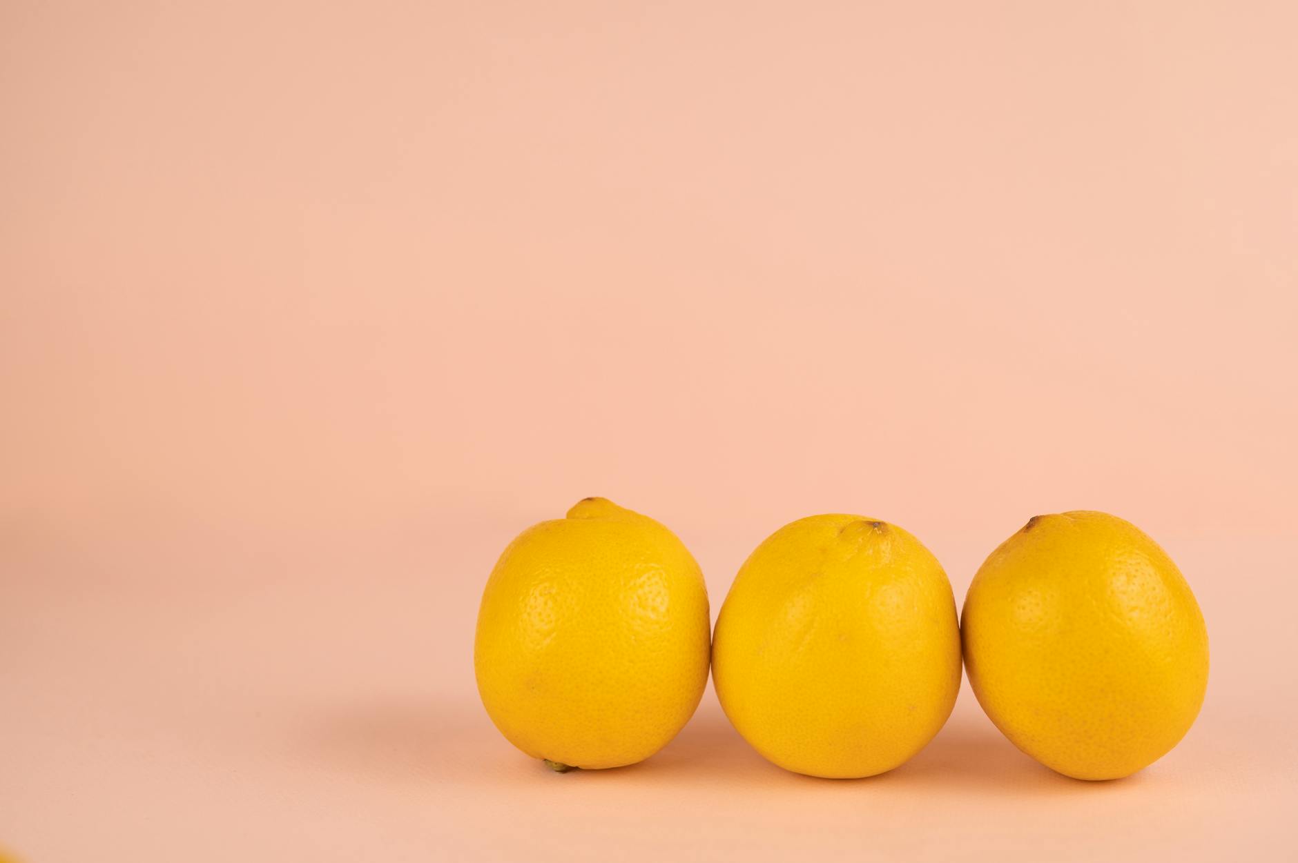 A vibrant arrangement of fresh lemons on a pastel background with a soft, peaceful aesthetic.